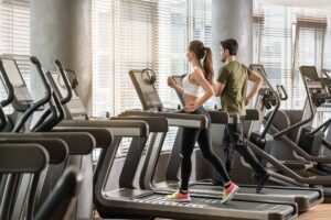 Mann und Frau auf Laufband im Fitnessstudio