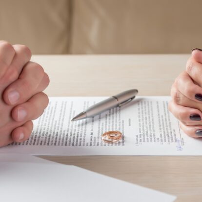 wife and husband signing divorce documents or premarital agreement