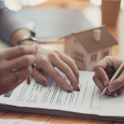 Cropped image of real estate agent assisting client to sign cont
